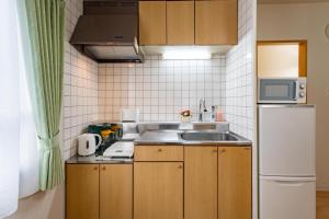 a small kitchen with a sink and a refrigerator at Sapporo Residential Juno in Sapporo
