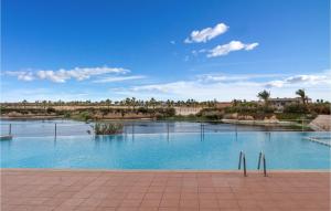 ein großes Schwimmbad mit einem Fluss im Hintergrund in der Unterkunft 2 Bedroom Cozy Apartment In Alhama De Murcia in El Romero