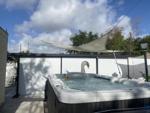 a swan swimming in a hot tub on a patio at Tiny place w private hot jacuzzi 7 min to Miami international airport in Miami