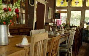 a dining room with a long table with chairs and flowers at Villa Warempel in Valkenburg +59 photos
