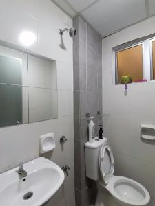 y baño con lavabo, aseo y espejo. en Ijanina Homestay en Bandar Puncak Alam