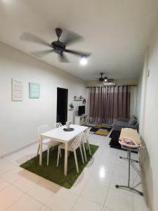 Ijanina Homestay في Bandar Puncak Alam: غرفة معيشة مع طاولة وكراسي بيضاء
