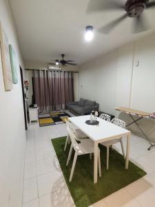 Ijanina Homestay في Bandar Puncak Alam: غرفة معيشة مع طاولة وكراسي بيضاء
