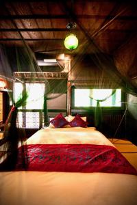 1 dormitorio con 1 cama grande con almohadas rojas en Traditional house, Blue moon villa, 古民家 蒼月庵 en Kimitsu