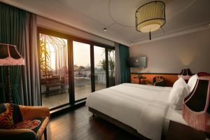 Schlafzimmer mit einem Bett und einem großen Fenster mit einem Balkon in der Unterkunft HOTEL du LAC Hanoi in Hanoi