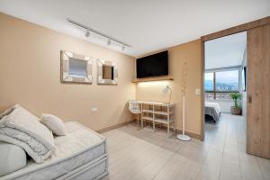 un soggiorno con divano, TV e scrivania di Aptos Alcazar Oviedo By HOUSY HOST a Medellín