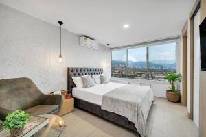 1 dormitorio con cama, sofá y ventana en Aptos Alcazar Oviedo By HOUSY HOST, en Medellín