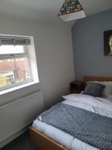 No 6 Decent Home (Cozy double bedroom) في آشتون أندر لين: غرفة نوم بسرير ونافذة