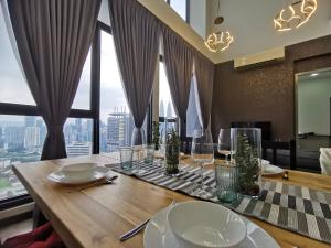 a dining room with a table with a view of the city at Expressionz Professional Suites by AURORA SUMMER SUITES in Kuala Lumpur
