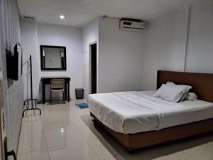 Un pat sau paturi într-o cameră la UNIK Guest House Syariah