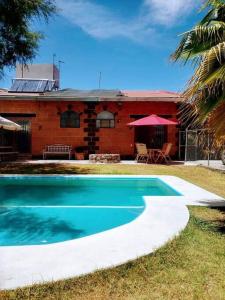 a house with a swimming pool in front of a house at Casa Ikal en San Juan del Rio con Alberca y Temazcal. in San Juan del Río