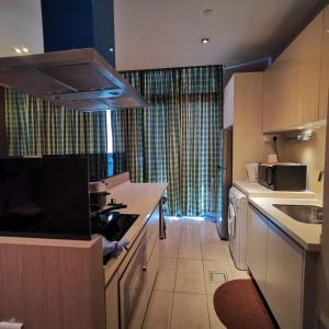 uma cozinha com um lavatório e um fogão forno superior em Walker's Suite@Riverson Soho superior one Bedroom em Kota Kinabalu