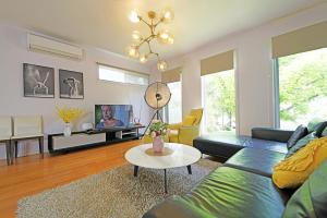 a living room with a couch and a table at Melbourne Luxury Villa at Doncaster in Nunawading