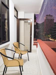 zwei Stühle und ein Tisch in einem Raum mit einem Fenster in der Unterkunft Apartamento Rodadero Santa Marta Edificio Santorini in Rodadero