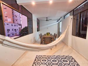 eine Hängematte in einem Raum mit Tisch und Stühlen in der Unterkunft Apartamento Rodadero Santa Marta Edificio Santorini in Rodadero