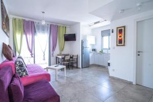 a living room with a purple couch and a kitchen at Yam Suf By Sun and View in Eilat