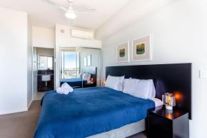 1 dormitorio con cama azul y manta azul en Ocean View Apartment Yeppoon, en Yeppoon