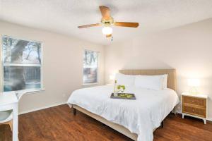 a bedroom with a white bed and a ceiling fan at 3B Villa w Pool, BBQ, Firepit, Yard Games, Gym in San Antonio +34 photos