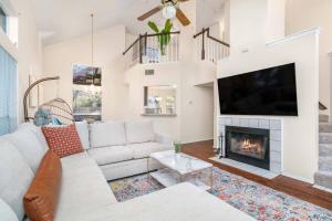 a living room with a white couch and a fireplace at 3B Villa w Pool, BBQ, Firepit, Yard Games, Gym in San Antonio