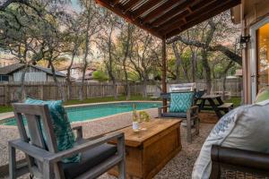 a patio with two chairs and a table and a pool at 3B Villa w Pool, BBQ, Firepit, Yard Games, Gym in San Antonio
