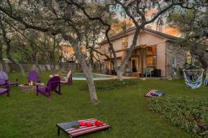 a yard with chairs and a table and a house at 3B Villa w Pool, BBQ, Firepit, Yard Games, Gym in San Antonio