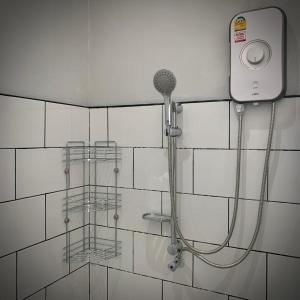 a shower with a hose attached to a tiled wall at Island House Rentals 26 in Ko Samed