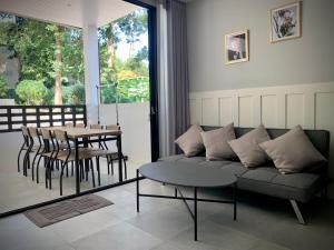 uma sala de estar com um sofá, uma mesa e cadeiras em Island House Rentals 26 em Ko Samet