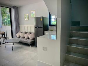 a kitchen with a refrigerator and a couch and a table at Island House Rentals 26 in Ko Samed