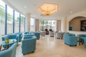 a waiting room with blue chairs and tables and windows at Thien Thanh Resort in Phu Quoc