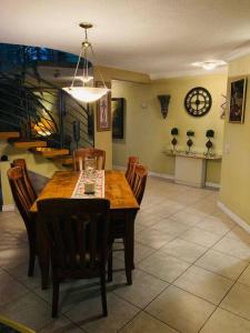 a dining room with a table and chairs and a clock at Casa de Luis in Tijuana