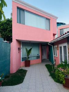 a pink house with a potted plant in front of it at Casa de Luis in Tijuana