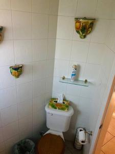 a bathroom with a toilet with a shelf on the wall at Casa de Luis in Tijuana