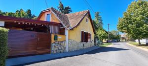 a house with a wooden garage door on a street at Belloapartamento Ház Balatonkenese, Strand 800m, Jakuzzi in Balatonkenese