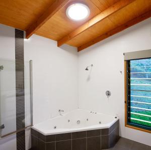 ein großes Bad mit einer Badewanne und einer Dusche in der Unterkunft Dayboro Cottages in Dayboro