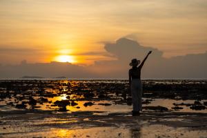 a man standing on the beach at sunset at Libong Beach Resort in Ko Libong