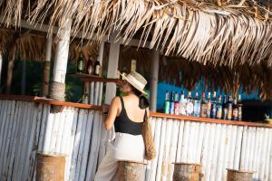 a woman in a hat standing behind a bar at Libong Beach Resort in Ko Libong
