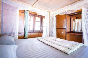 ein Schlafzimmer mit einem weißen Bett mit Baldachin in der Unterkunft Libong Beach Resort in Ko Libong