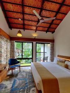 ein Schlafzimmer mit einem großen Bett und großen Fenstern in der Unterkunft Willow Resorts in Ambalavayal