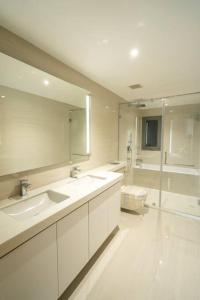 a bathroom with two sinks and a toilet and a mirror at Altair Colombo - View, Location, Ultra Luxury! in Colombo