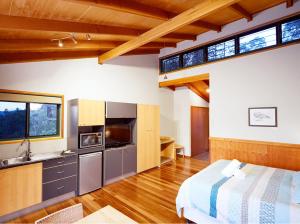 Habitación con cama y cocina con ventanas. en Dayboro Cottages en Dayboro