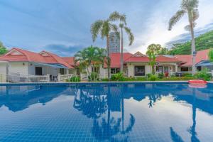 una piscina davanti a una casa con palme di 15BR-30PAX,300m-Beach & 8mins Walking Street for Families & Group Retreat a Pattaya Sud