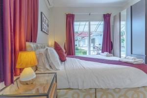 una camera da letto con un grande letto con tende viola di 15BR-30PAX,300m-Beach & 8mins Walking Street for Families & Group Retreat a Pattaya Sud