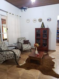 uma sala de estar com duas cadeiras e uma mesa em Casa Grande da Montanha - Sítio Pasangas em Santo Antônio do Pinhal