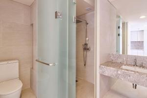 a bathroom with a shower and a toilet and a sink at The Island Blue Hotel in Seogwipo