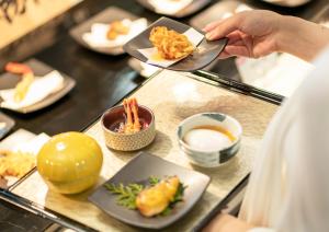a person holding a plate of food on a buffet at Kyoto Yamashina Hotel Sanraku in Kyoto