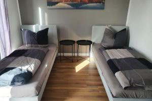 twee bedden in een kamer met twee krukken bij Work & Stay Apartment Ingolstadt in Ingolstadt