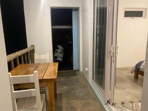 a dining room with a table and a glass door at Kite Room in Rodrigues Island