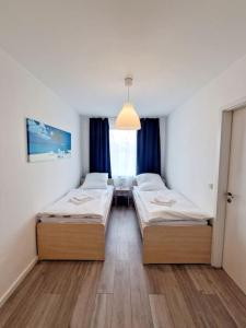 two beds in a room with blue curtains at charming apartment in the center of Berlin 34 in Berlin