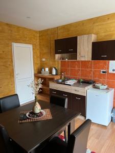 a kitchen with a table and a white refrigerator at Apartments Vila Brzi & Beka in Šabac