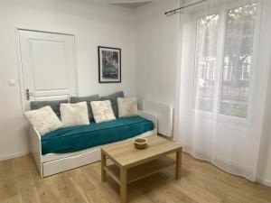 a living room with a blue couch and a table at * L'appartement centre de Provins * ZEN LOC 4 in Provins